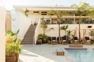 a resort with a swimming pool with chairs and a staircase at Hotel June West LA, a Member of Design Hotels in Los Angeles