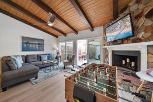 sala de estar con mesa de juegos y chimenea en Steps to the Sand and Main Street 4BR, en Huntington Beach