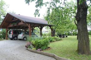 un pabellón de madera con un coche aparcado en un parque en Apartma Vrh en Lesce