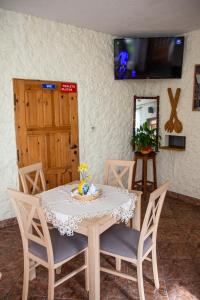 a dining room with a table with chairs and a television at Zajazd U Julii in Miastko