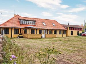 a large yellow house with an orange roof at 8 person holiday home in Allinge in Allinge