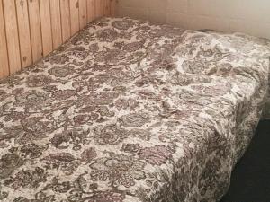 a bed with a flowered blanket on top of it at 6 person holiday home in Vinderup in Vinderup