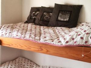 a wooden bunk bed with a comforter on it at 6 person holiday home in Vinderup in Vinderup