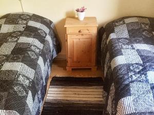 een slaapkamer met 2 bedden en een houten nachtkastje bij 6 person holiday home in Vinderup in Vinderup