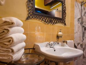 a bathroom with a sink and a mirror and towels at OASI LIGNANA Apartments in Pescia