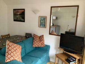 uma sala de estar com um sofá azul e um espelho em Primrose Villa self catering bnb em Monmouth