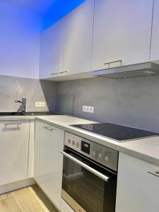 a kitchen with white cabinets and an oven at 3-Raum Apartment Quartier57 Hamburg-Eppendorf in Hamburg