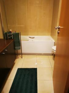 een badkamer met een bad en een toilet bij White Family House in Aveiro