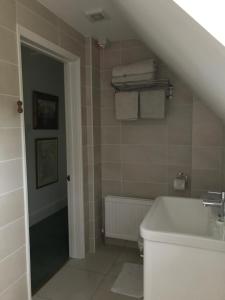 uma casa de banho com um lavatório e uma banheira em Lane End Cottage em Ovington
