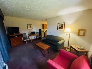 a living room with a couch and a tv at Fleetwood Inn Suites in Cheboygan