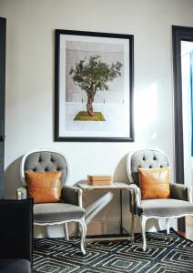 uma sala de estar com duas cadeiras e uma foto de uma árvore em Art Pantheon - Suites & Apartments em Atenas
