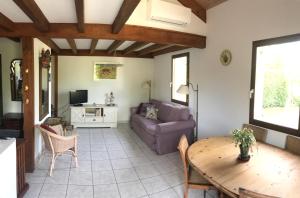 a living room with a table and a couch at Maison de vacances village Océlandes in Saint-Julien-en-Born