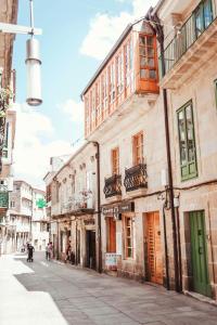 an empty city street with buildings and people walking down it at Dúplex Camino de Santiago I, Rúa Real, Pontevedra in Pontevedra