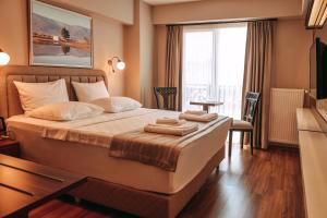 ein Schlafzimmer mit einem Bett mit zwei Handtüchern darauf in der Unterkunft Armida City Hotel in Canakkale