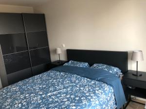 デ・パンネにあるFalcon beach appartment 0401の青いシーツと枕が備わったベッドのある寝室