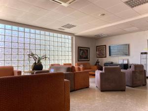 una sala d'attesa con divani, tavoli e finestre di Hotel Paraiso a Oliveira do Bairro