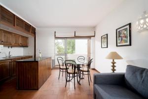 ヴィラモウラにあるAL - Apartamento Impervilaのキッチン、リビングルーム(テーブル、椅子付)