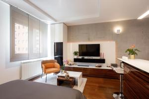 een kamer met een bed en een woonkamer met een televisie bij Elegant Urban Escape Self Check-In, Free Garage in Belgrade in Belgrado