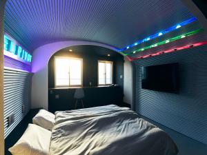 a room with a bed with lights on the ceiling at Hotel Pivot Shin-Imamiya Ekimae in Osaka