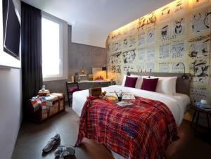 a bedroom with a large bed with a red blanket at ARTOTEL Thamrin Jakarta in Jakarta