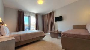 a hotel room with a bed and a window at Vasiliki House in Sarti