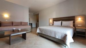 a bedroom with a bed and a couch and a table at Vasiliki House in Sarti