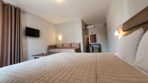 a hotel room with a bed and a couch at Vasiliki House in Sarti
