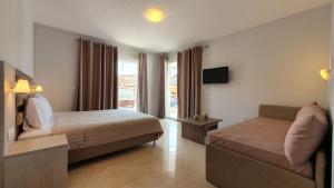a hotel room with a bed and a couch at Vasiliki House in Sarti