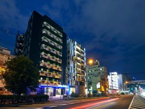 a city street with tall buildings at night at Hotel Pivot Shin-Imamiya Ekimae in Osaka
