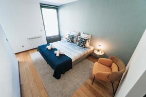 niewielka sypialnia z łóżkiem i krzesłem w obiekcie Refugio do Gerês-Apartamento w mieście Geres