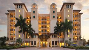 a large building with palm trees in front of it at Holiday Inn Club Vacations Sunset Cove Resort in Marco Island