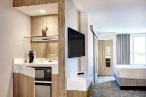 a hotel room with a bed and a microwave at SpringHill Suites by Marriott Springfield North in Springfield