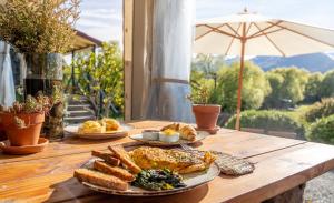 una mesa de madera cubierta con platos de comida y pan en EcoScapes, en Glenorchy