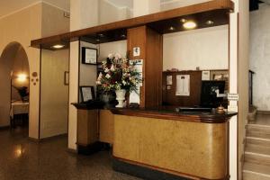 eine Lobby mit einer Theke mit Blumen darauf in der Unterkunft Hotel Residence Mediterraneo in Diano Marina