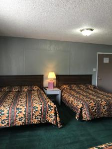 a hotel room with two beds and a table with a lamp at Thunderchief Inn in South Lake Tahoe