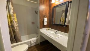 uma casa de banho com um lavatório, um WC e uma banheira em Villa Park Motel em Orange