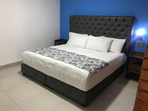 Schlafzimmer mit einem großen Bett mit einem schwarzen Kopfteil in der Unterkunft Hotel Jar8 Acuario enfrente al Acuario de Veracruz in Veracruz