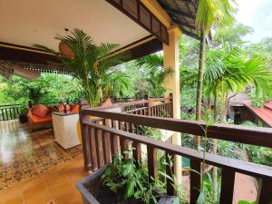 einen Balkon eines Hauses mit Palmen in der Unterkunft Residence Indochine Suite in Siem Reap