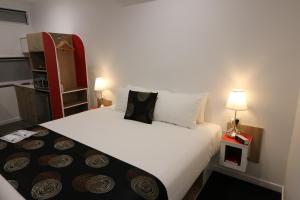 a hotel room with two beds and two lamps at Room Motels Kingaroy in Kingaroy