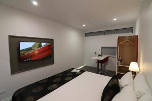 a living room filled with furniture and a tv at Room Motels Kingaroy in Kingaroy