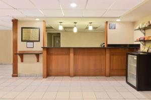 a waiting room with a counter and a mirror at Howard Johnson by Wyndham Allentown/Dorney Hotel & Suites in Allentown