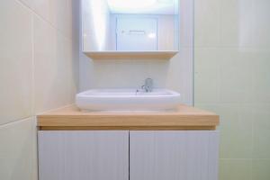 a bathroom with a white sink and a mirror at Relax 3BR Apartment at M-Town Residence By Travelio in Tangerang +18 photos