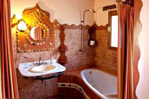 uma casa de banho com um lavatório, uma banheira e um espelho. em Posada Del Río Carbo em Villahermosa del Río