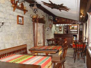 un restaurante con mesas de madera y sillas en una habitación en Dona Guest House - Horse Riding, en Koprivshtitsa