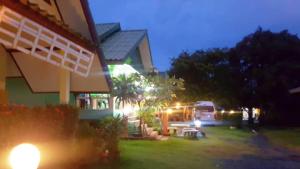 a house with a yard at night with a bus at สุขกมลรับอรุณแฝด2ห้อง in Chanthaburi