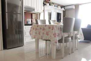 バンドンにあるCozy 2BR Apartment at Tamansari Tera Residence near BIP By Travelioのテーブルと椅子、冷蔵庫のあるキッチン