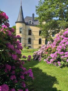 una casa con un mazzo di fiori davanti di Château Les Tourelles a Bertrix
