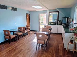 a dining room with tables and chairs and a kitchen at Travelodge by Wyndham Forsyth in Forsyth