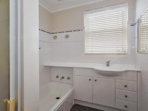 uma casa de banho branca com um lavatório e uma banheira em Sebastapol, 4,66 Thurlow Avenue - Unit with wonderful views across the bay em Nelson Bay