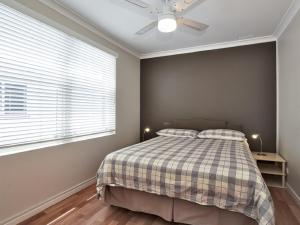 um quarto com uma cama e uma ventoinha de tecto em Sebastapol, 4,66 Thurlow Avenue - Unit with wonderful views across the bay em Nelson Bay